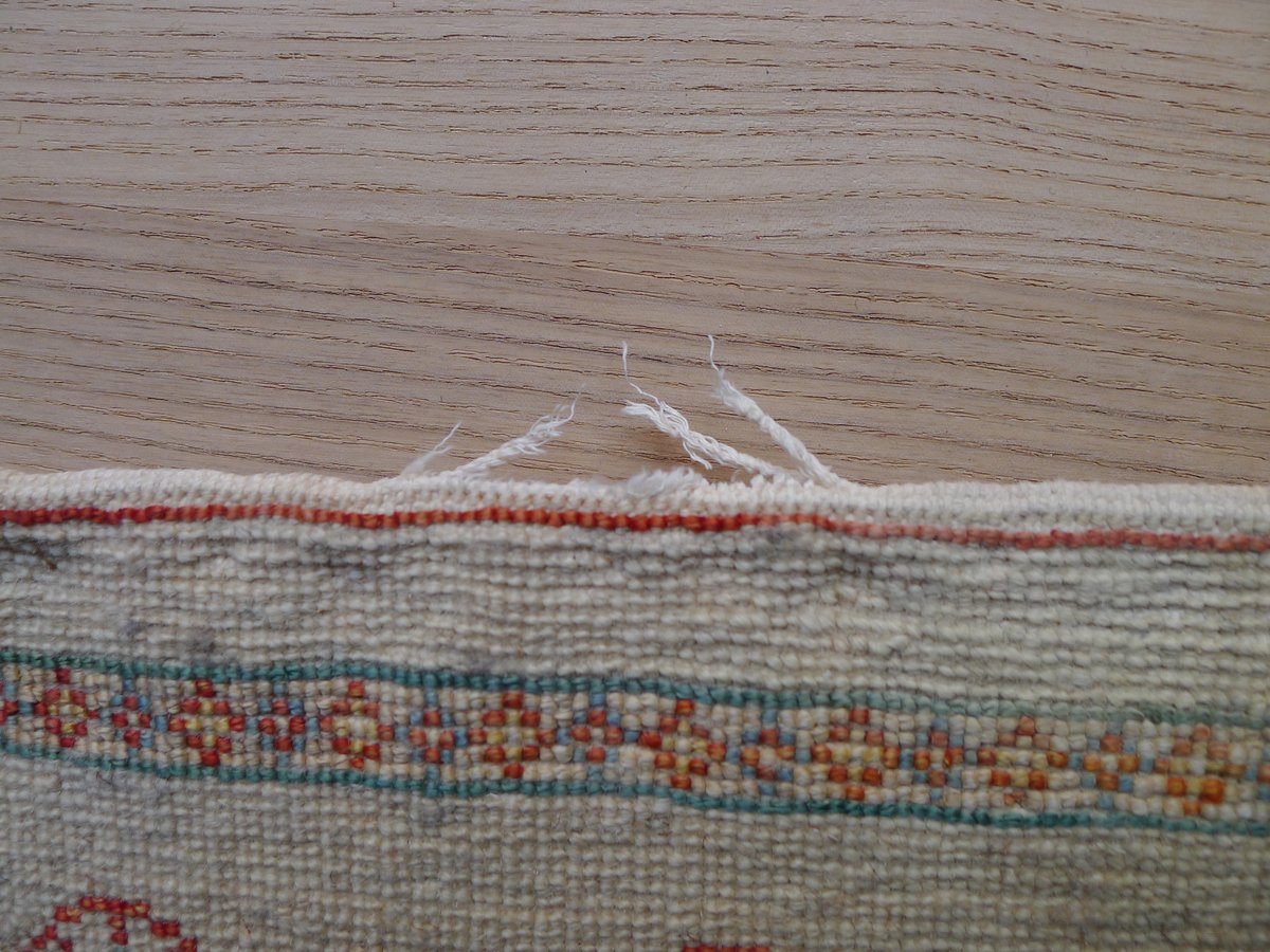 扉に引っかかって、端の糸が切れたギャッベ