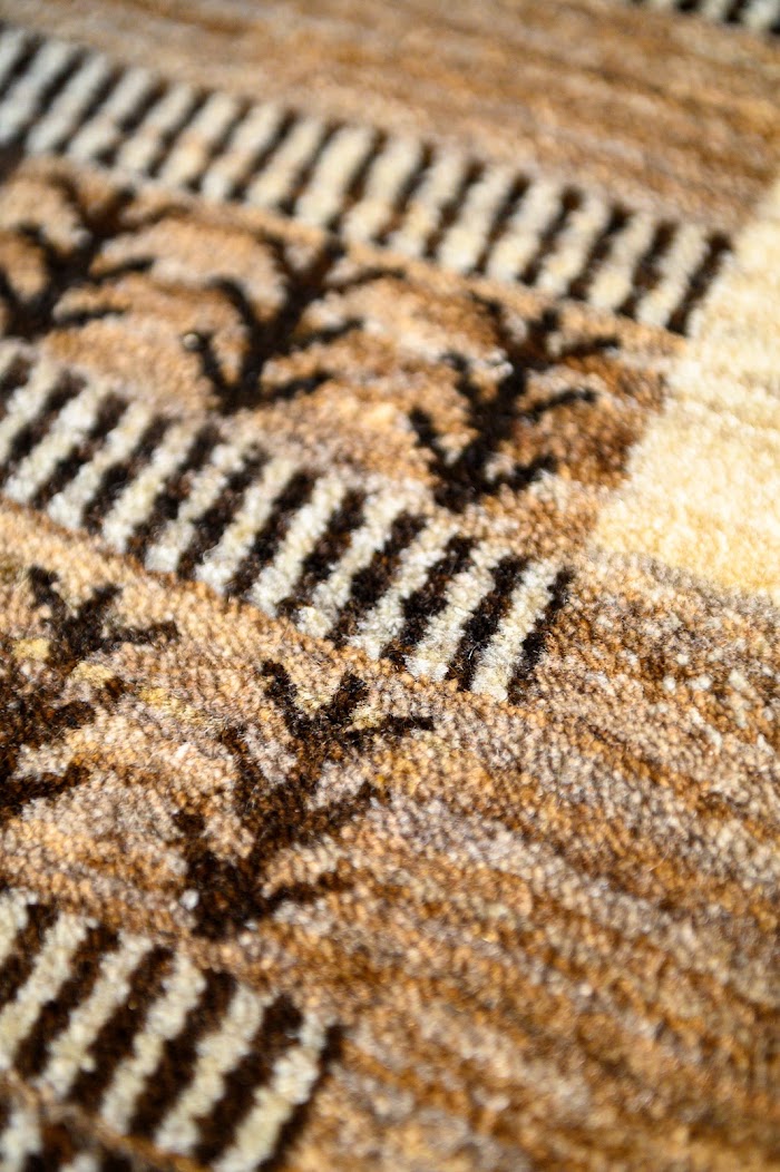 茶と白の縞に、黒い木の文様が並ぶギャッベの寄り